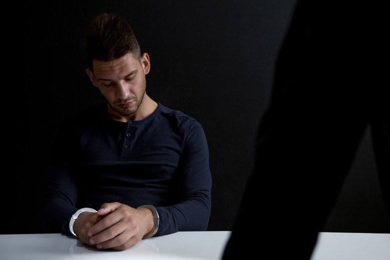 Suspect or criminal man with handcuffs  in interrogation room