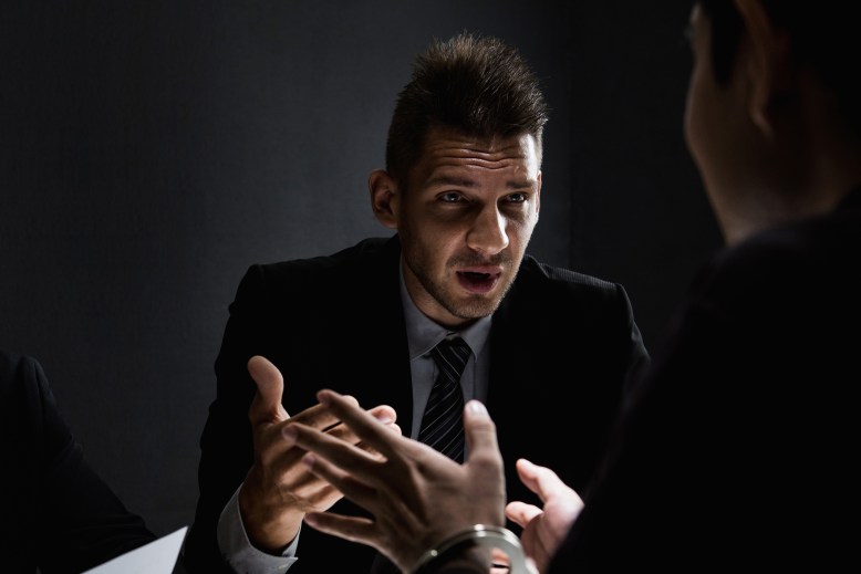 Criminal man being interviewed in interrogation room after committed a crime